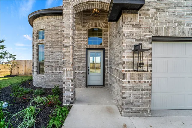 front view of a brick house with a small yard