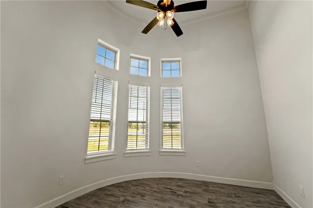 an empty room with a window and a ceiling fan