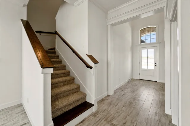 a view of a hallway with wooden floor and entryway