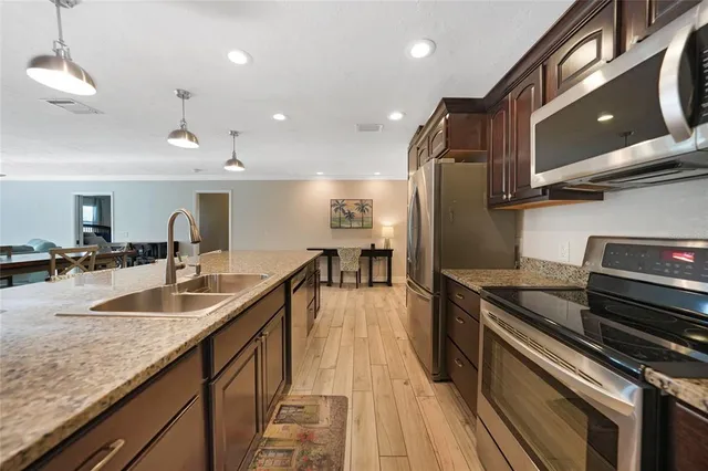 a kitchen with stainless steel appliances granite countertop a refrigerator and a sink