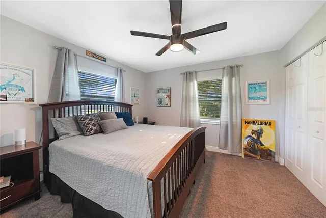 a bedroom with a bed and a chandelier fan