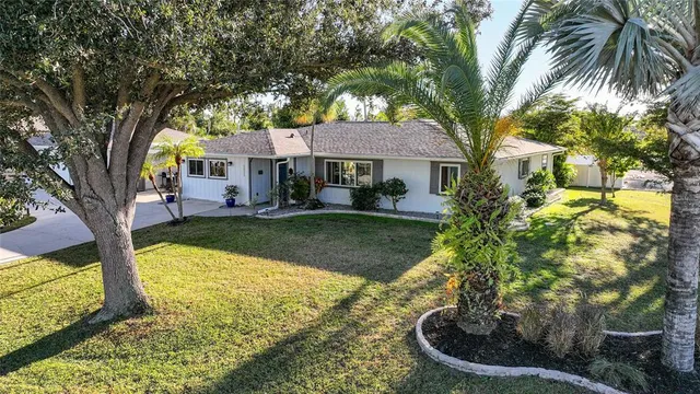 a view of a house with big yard and large trees
