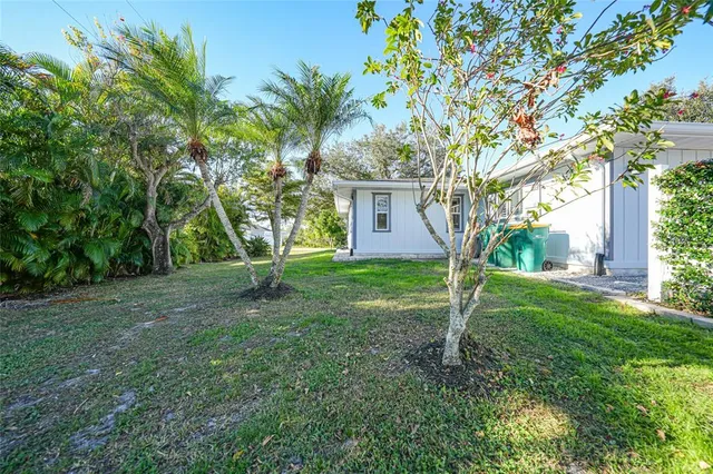 an aerial view of residential houses with outdoor space and trees