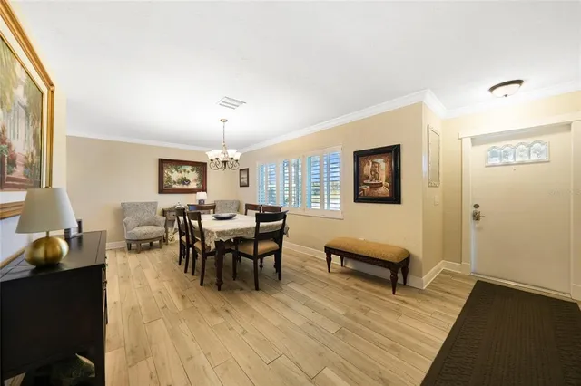 a view of a dining room with furniture a chandelier and wooden floor