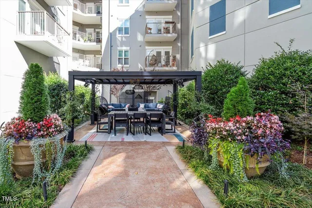 a patio with table and chairs and potted plants
