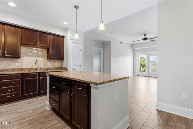 a kitchen with stainless steel appliances granite countertop a sink a stove and a wooden cabinets