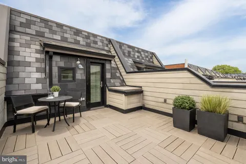 a roof deck with table and chairs