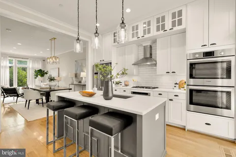a kitchen with stainless steel appliances kitchen island a stove a table and chairs