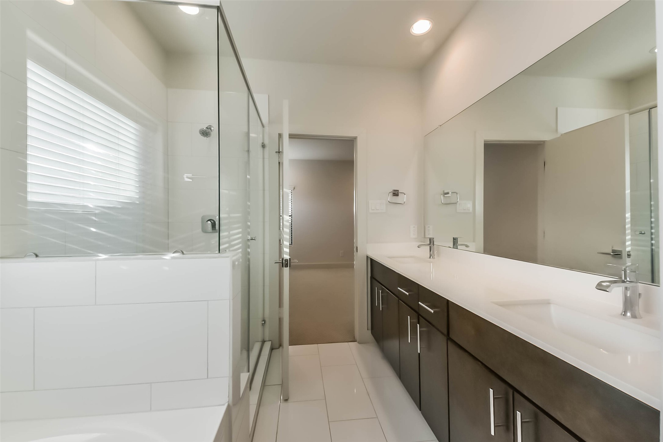 3206 North MacGregor Way, Unit A Houston, TX 77004 - Photo 11 of 30 a bathroom with a double vanity sink a large mirror and a bathtub