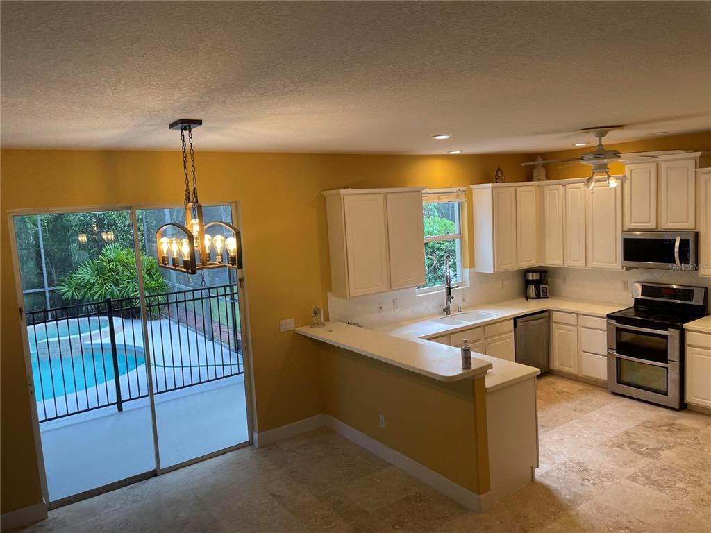 759 Fordingbridge Way Osprey, FL 34229 - Photo 32 of 51 a kitchen with stainless steel appliances granite countertop a sink a stove and a wooden floors