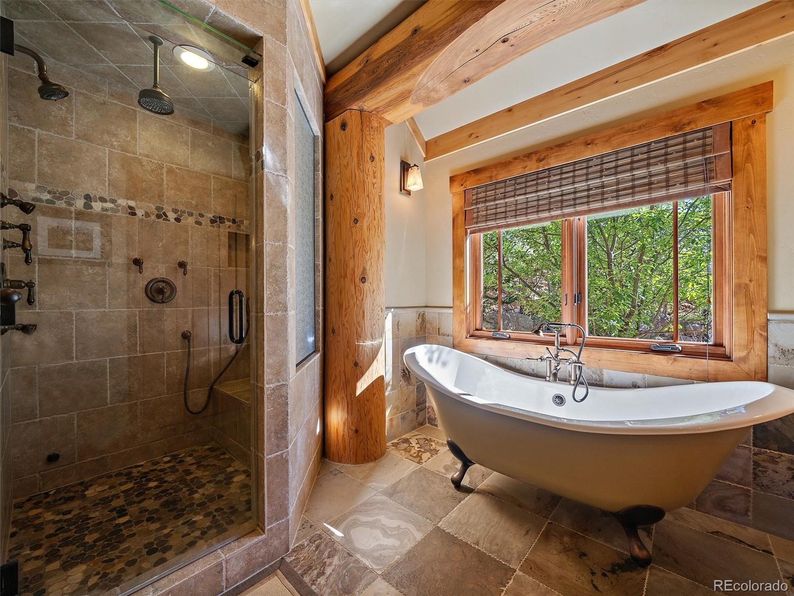 451 Bear Meadow Trail Evergreen, CO 80439 - Photo 11 of 45 a bath tub sitting in a bathroom next to a tub