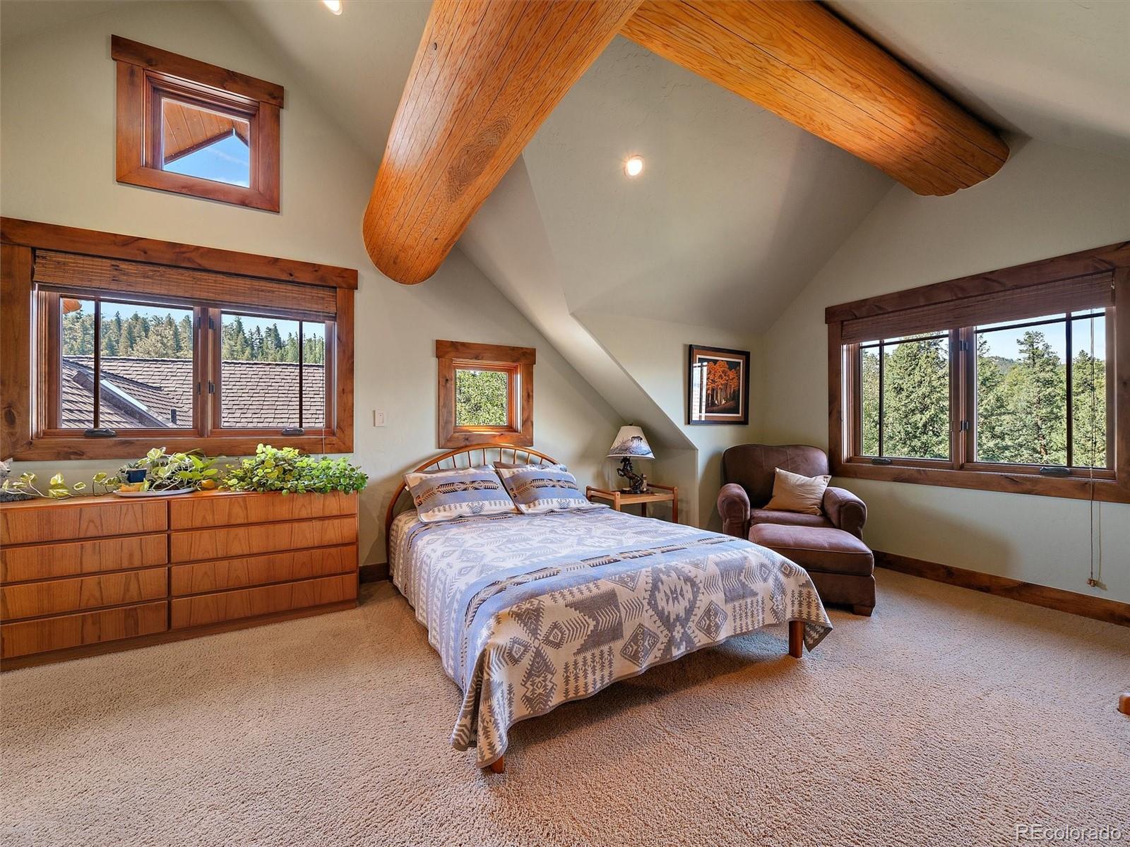 451 Bear Meadow Trail Evergreen, CO 80439 - Photo 15 of 45 a bedroom with a bed and a chandelier