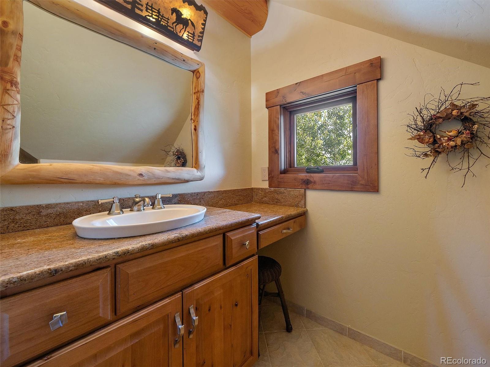 451 Bear Meadow Trail Evergreen, CO 80439 - Photo 16 of 45 a bathroom with a sink and a mirror