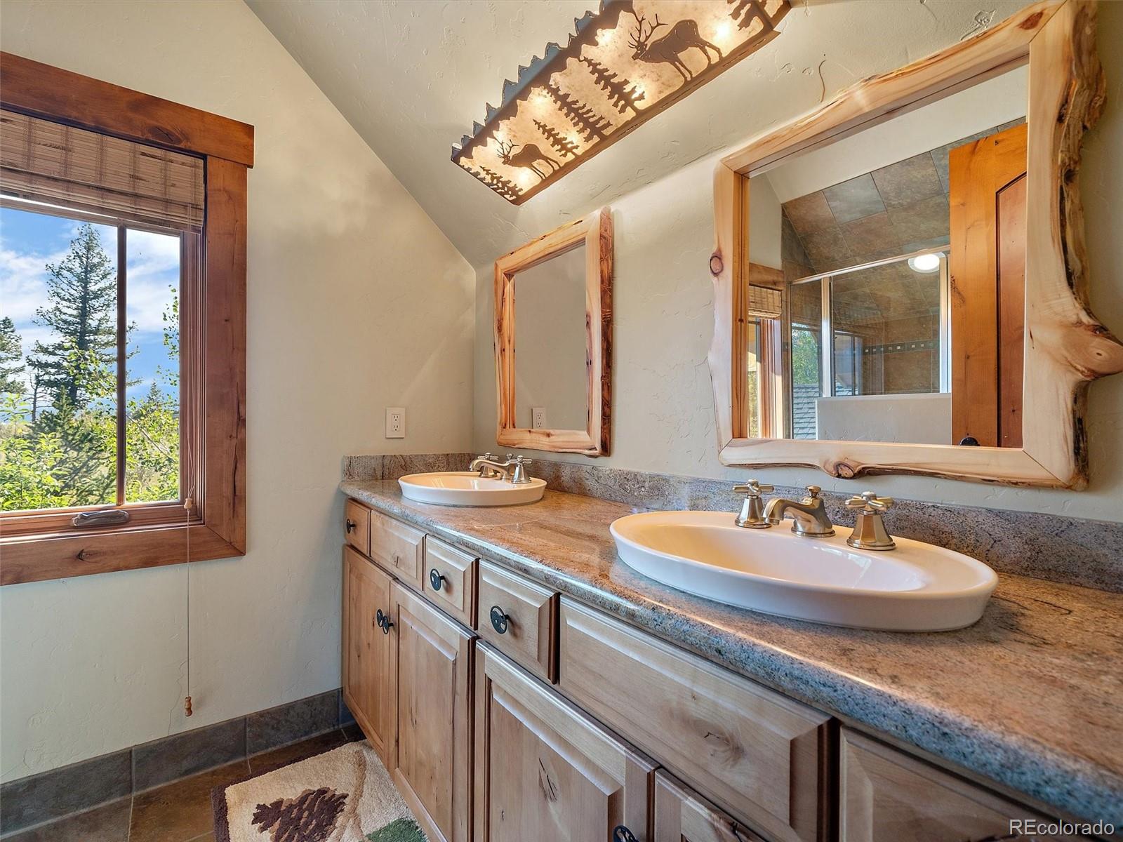 451 Bear Meadow Trail Evergreen, CO 80439 - Photo 19 of 45 a bathroom with a sink and a mirror