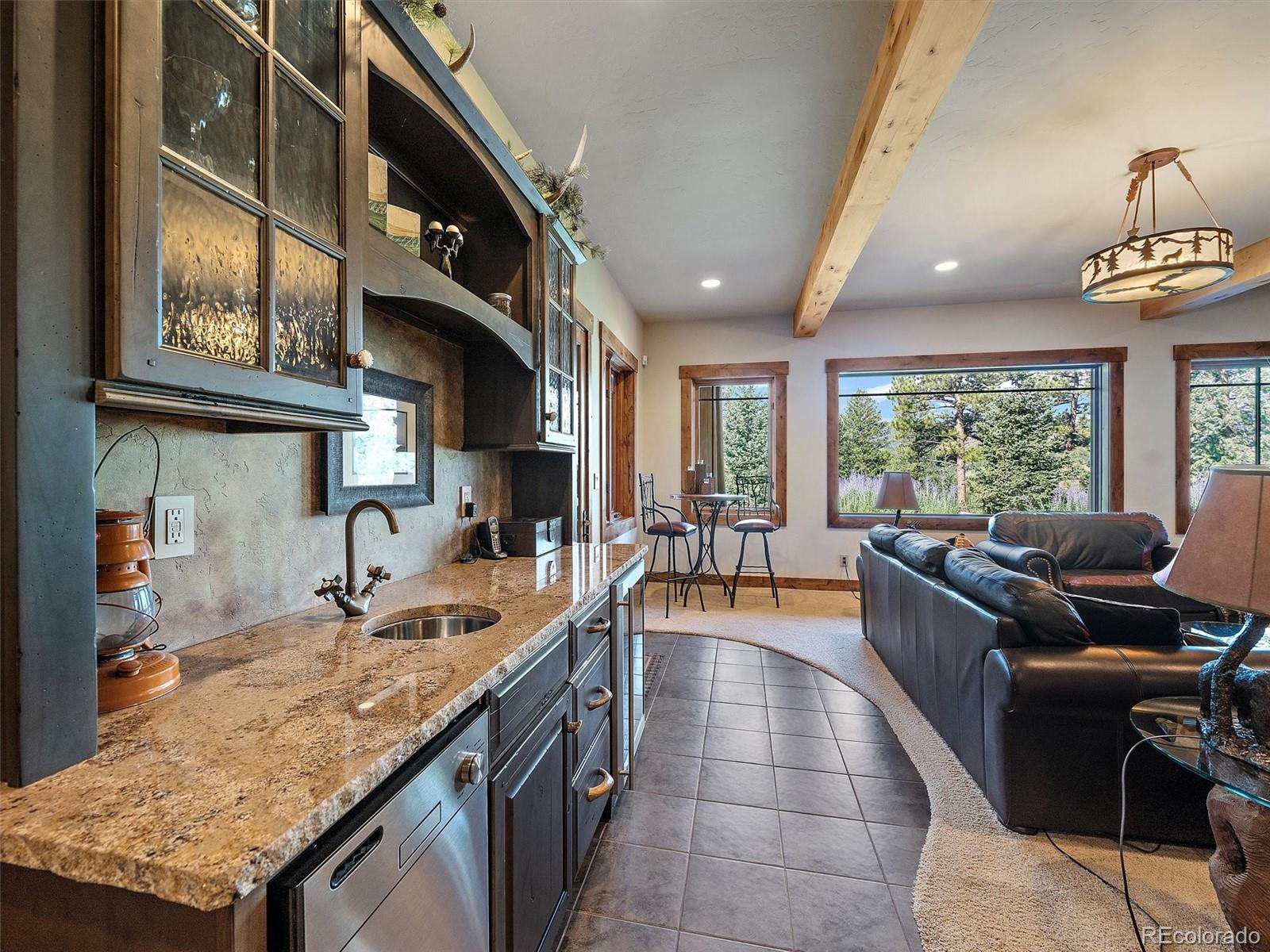 451 Bear Meadow Trail Evergreen, CO 80439 - Photo 23 of 45 a kitchen with stainless steel appliances granite countertop a sink and a large window
