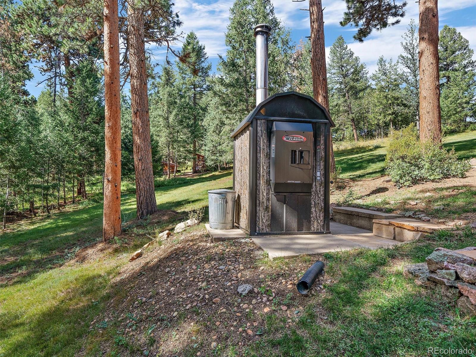 451 Bear Meadow Trail Evergreen, CO 80439 - Photo 42 of 45 a view of a tiny house with a yard and large trees
