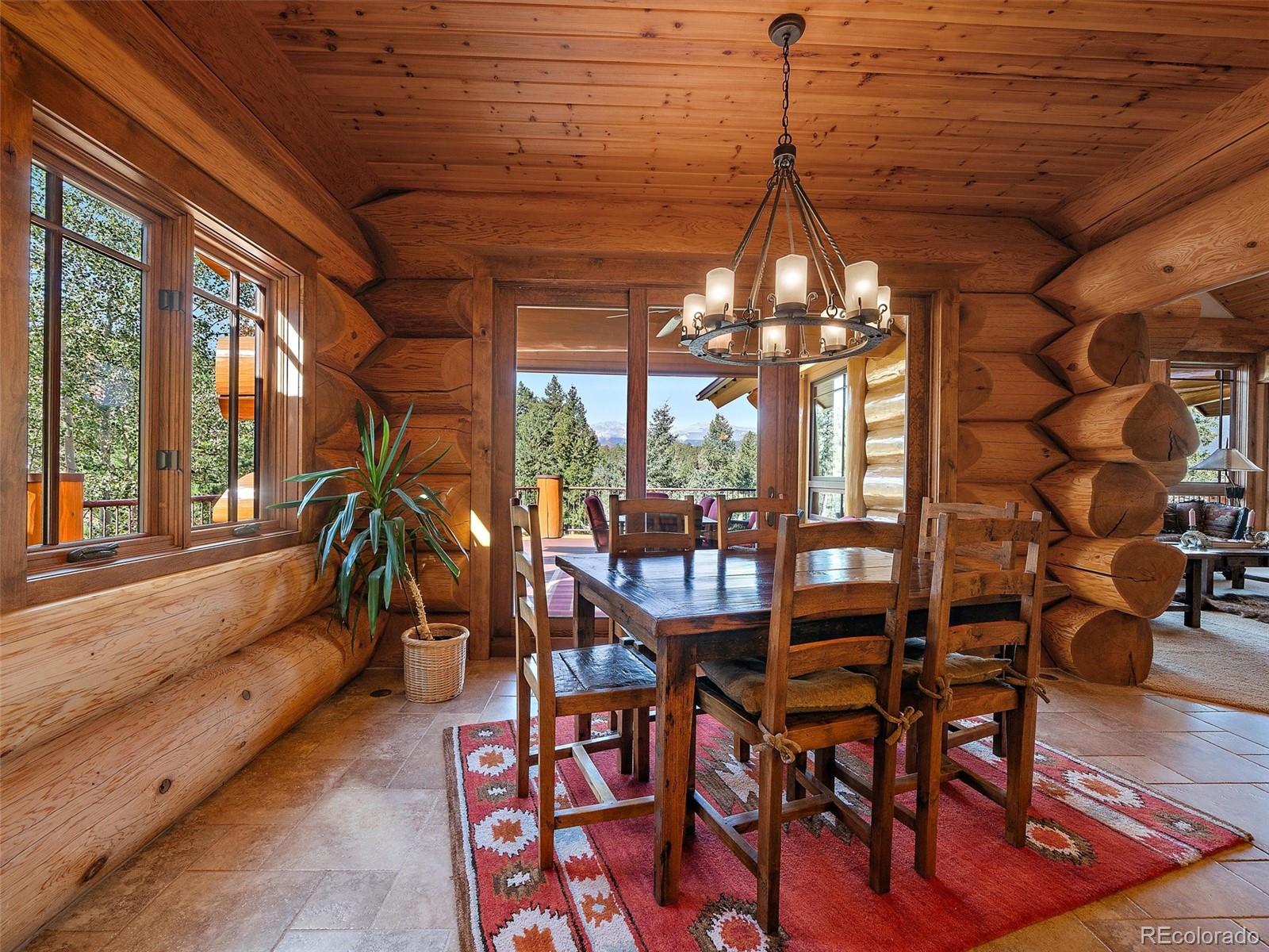 451 Bear Meadow Trail Evergreen, CO 80439 - Photo 8 of 45 a dining room with furniture wooden floor and a chandelier