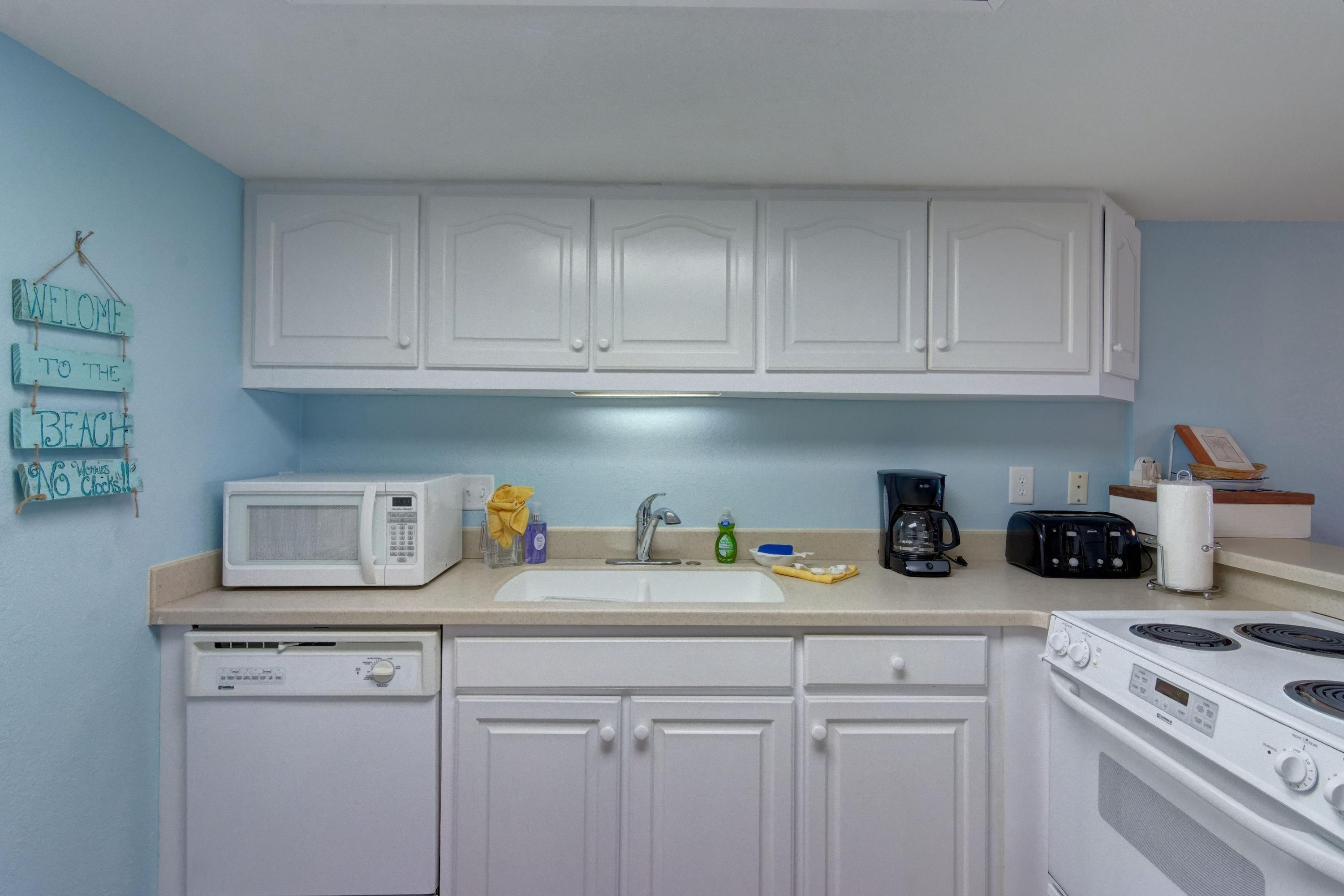 23223 Front Beach Road, Unit 701 Panama City Beach, FL 32413 - Photo 5 of 42 a kitchen with white cabinets and a sink
