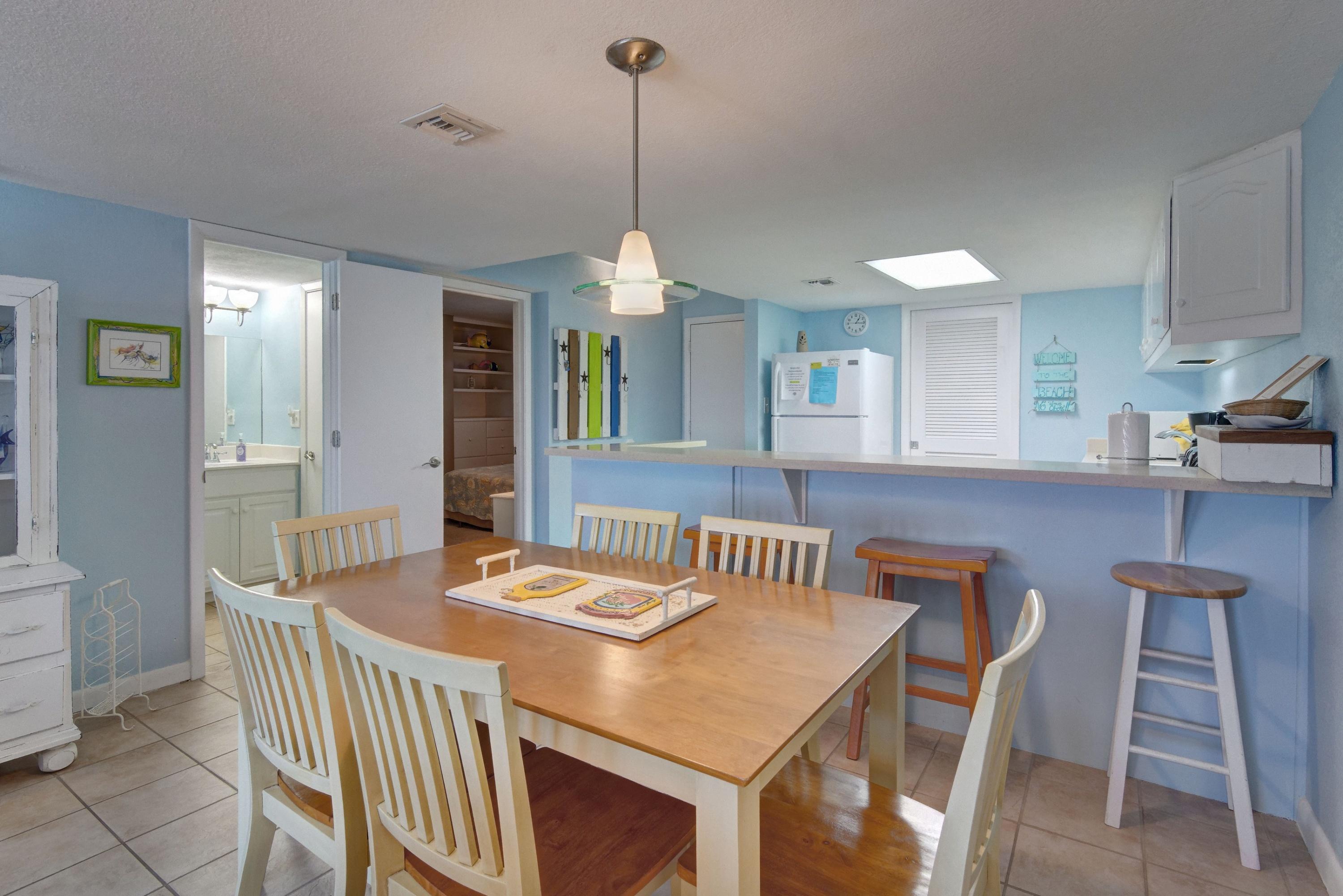23223 Front Beach Road, Unit 701 Panama City Beach, FL 32413 - Photo 7 of 42 a dining room with a table chairs and a kitchen view