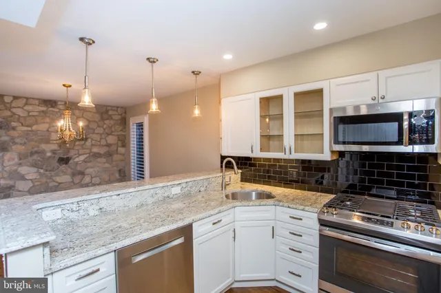 a bathroom with a granite countertop sink and mirror