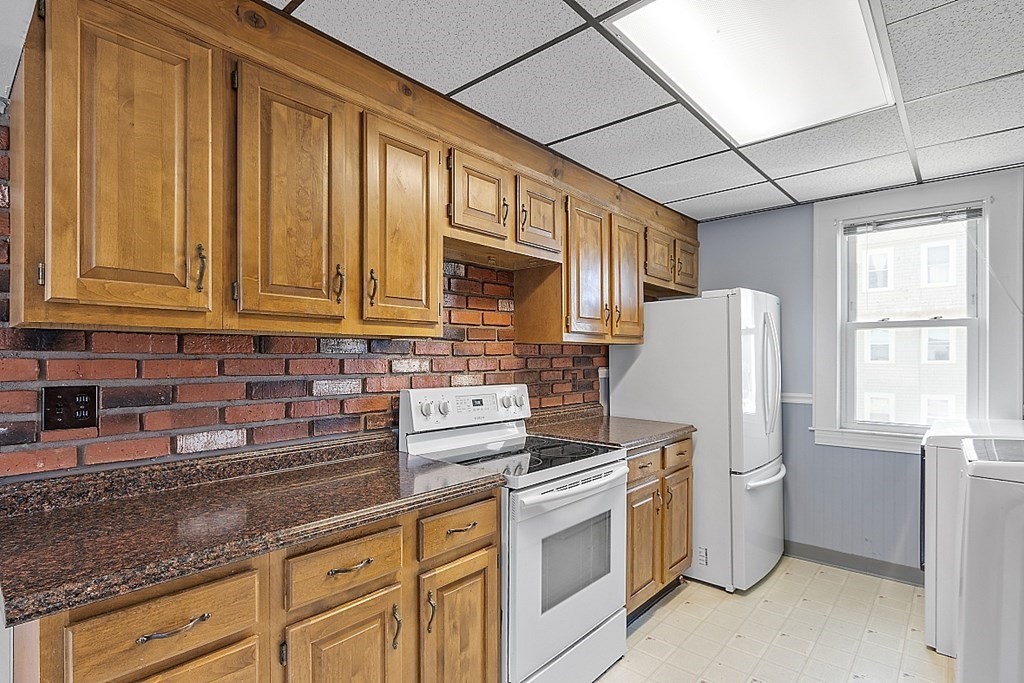 57 Vale Street Worcester, MA 01604 - Photo 26 of 39 a kitchen with stainless steel appliances granite countertop a refrigerator a stove a sink dishwasher and wooden cabinets with wooden floor
