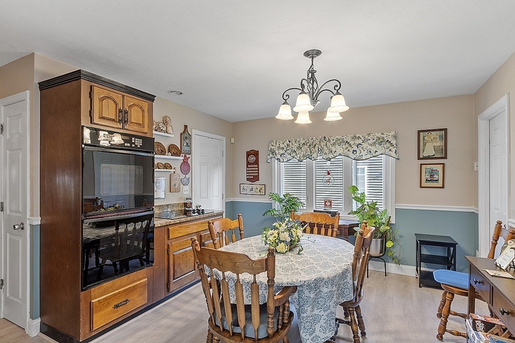 57 Vale Street Worcester, MA 01604 - Photo 8 of 39 a dining room with wooden floor a chandelier a wooden table and chairs