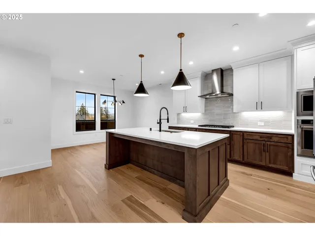 a kitchen that has a lot of cabinets and wooden floor