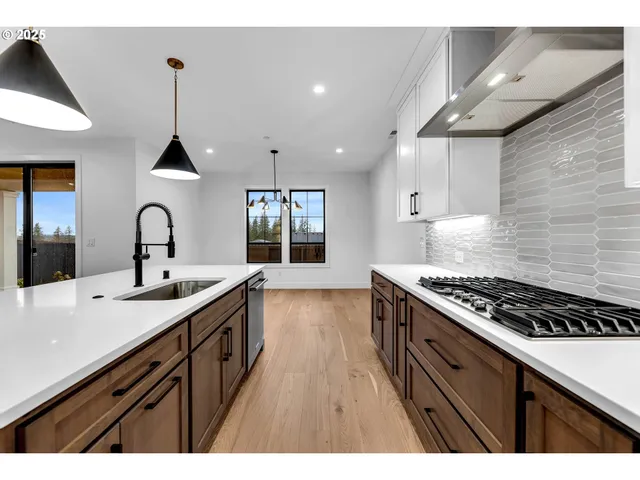 a kitchen with kitchen island a sink appliances and wooden floor