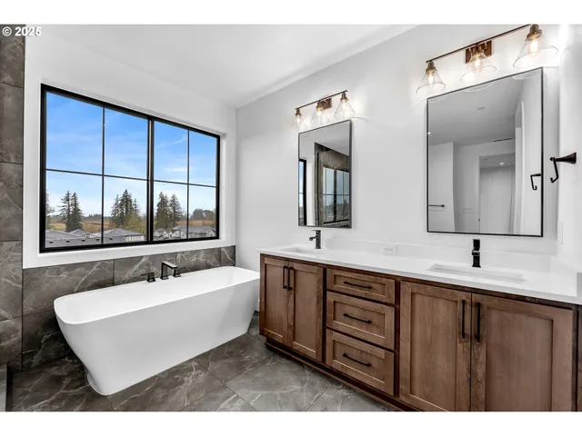 a view of an empty room with wooden floor and fan