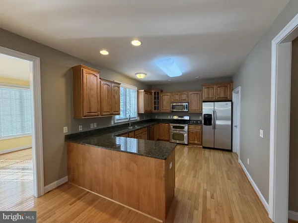 a kitchen with stainless steel appliances granite countertop a refrigerator a stove and a sink