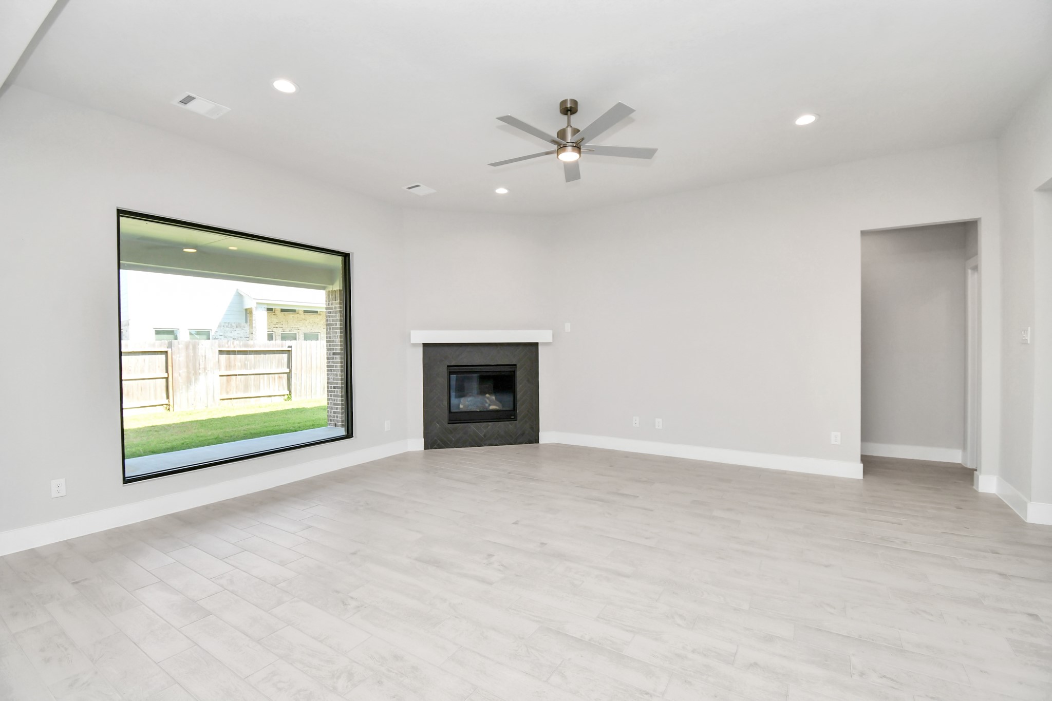 3106 Native Spg Drive Spring, TX 77373 - Photo 19 of 38 Family room flooded with natural light through the expansive windows. The premium tile flooring adds a touch of luxury to the space, creating the perfect setting for relaxing moments and cherished gatherings with loved ones. Sample photo of completed home with similar floor plan. Actual colors and selections may vary.