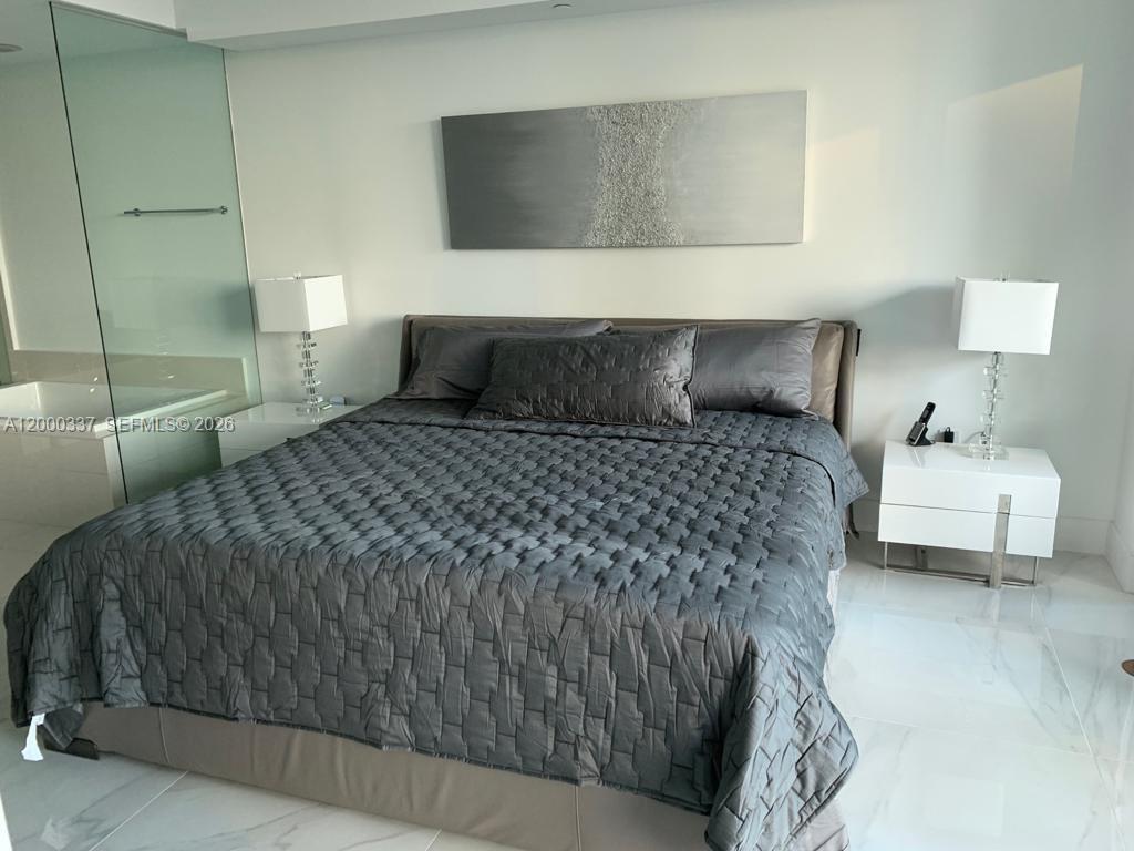 650 Northeast 32nd Street, Unit 705 Miami, FL 33137 - Photo 15 of 24 a bedroom with a bed and a couch