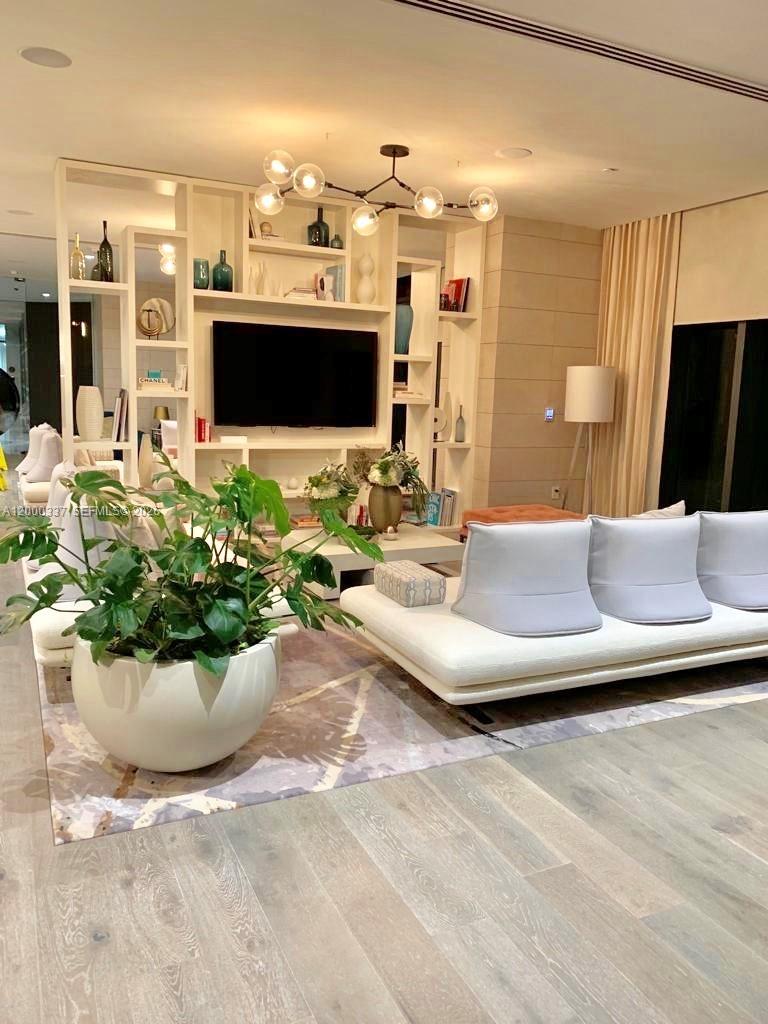 650 Northeast 32nd Street, Unit 705 Miami, FL 33137 - Photo 21 of 24 a living room with furniture and a flat screen tv
