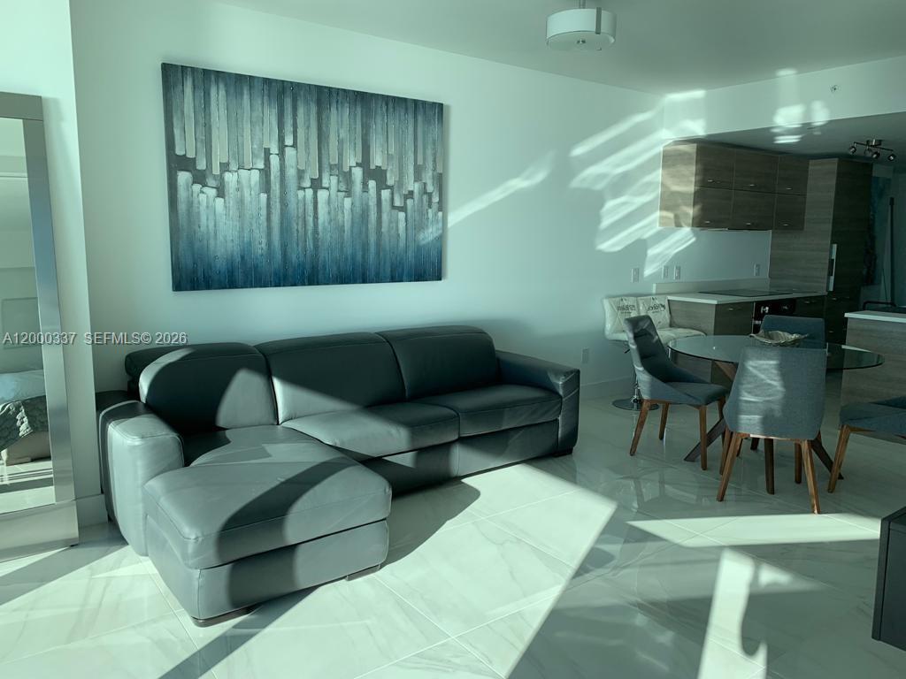650 Northeast 32nd Street, Unit 705 Miami, FL 33137 - Photo 5 of 24 a living room with furniture and a flat screen tv