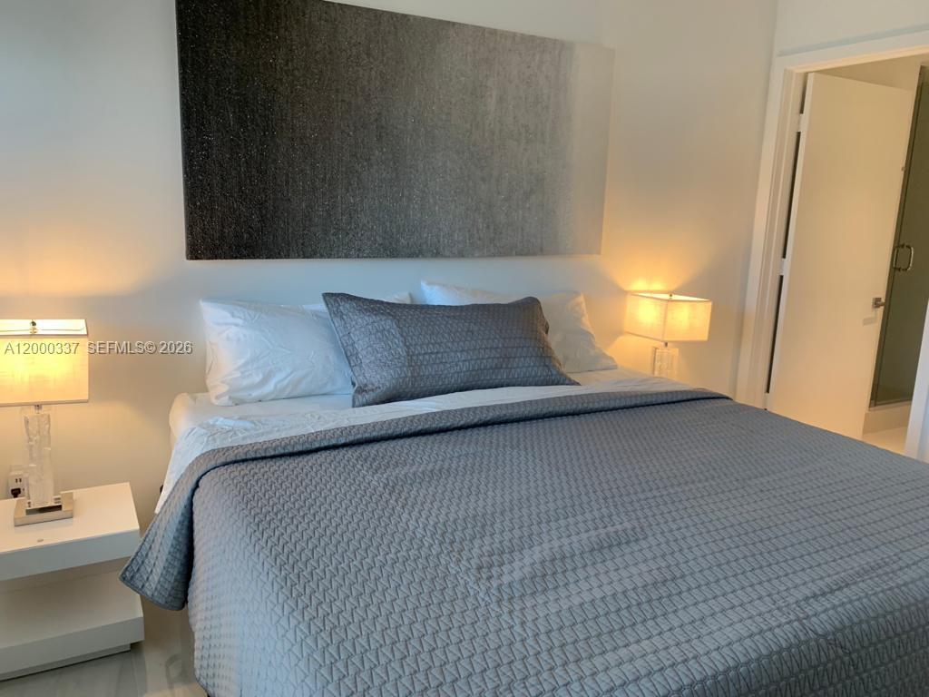 650 Northeast 32nd Street, Unit 705 Miami, FL 33137 - Photo 9 of 24 a bedroom with a bed and a window