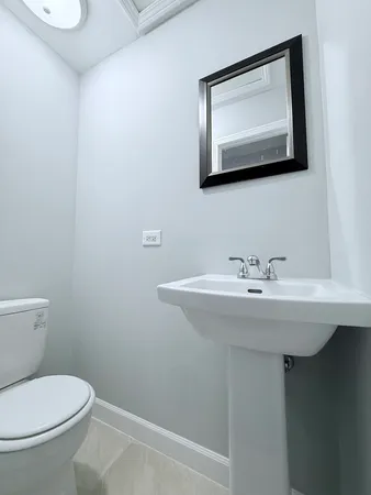 a bathroom with a toilet a sink and mirror