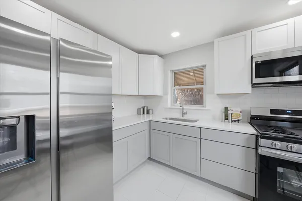 a kitchen with a sink stainless steel appliances and cabinets