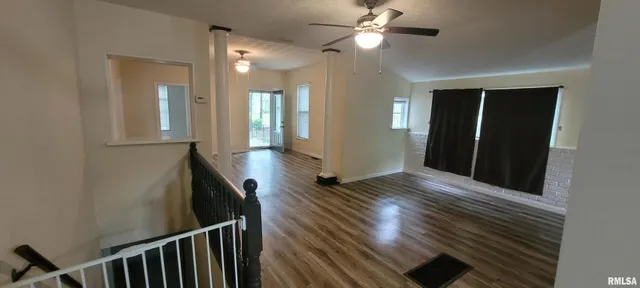 a view of a hallway with wooden floor and staircase