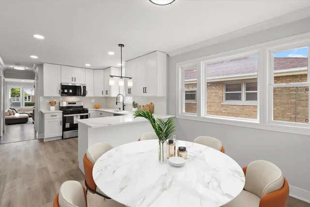 a kitchen with stainless steel appliances granite countertop a stove a kitchen island with a refrigerator a stove a dining table and chairs