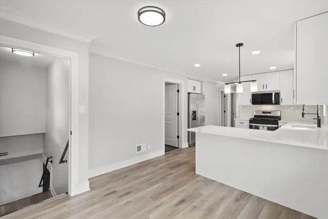 a view of kitchen with stainless steel appliances refrigerator stove microwave and refrigerator