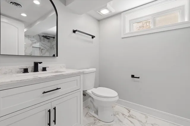 a bathroom with a sink a toilet and mirror