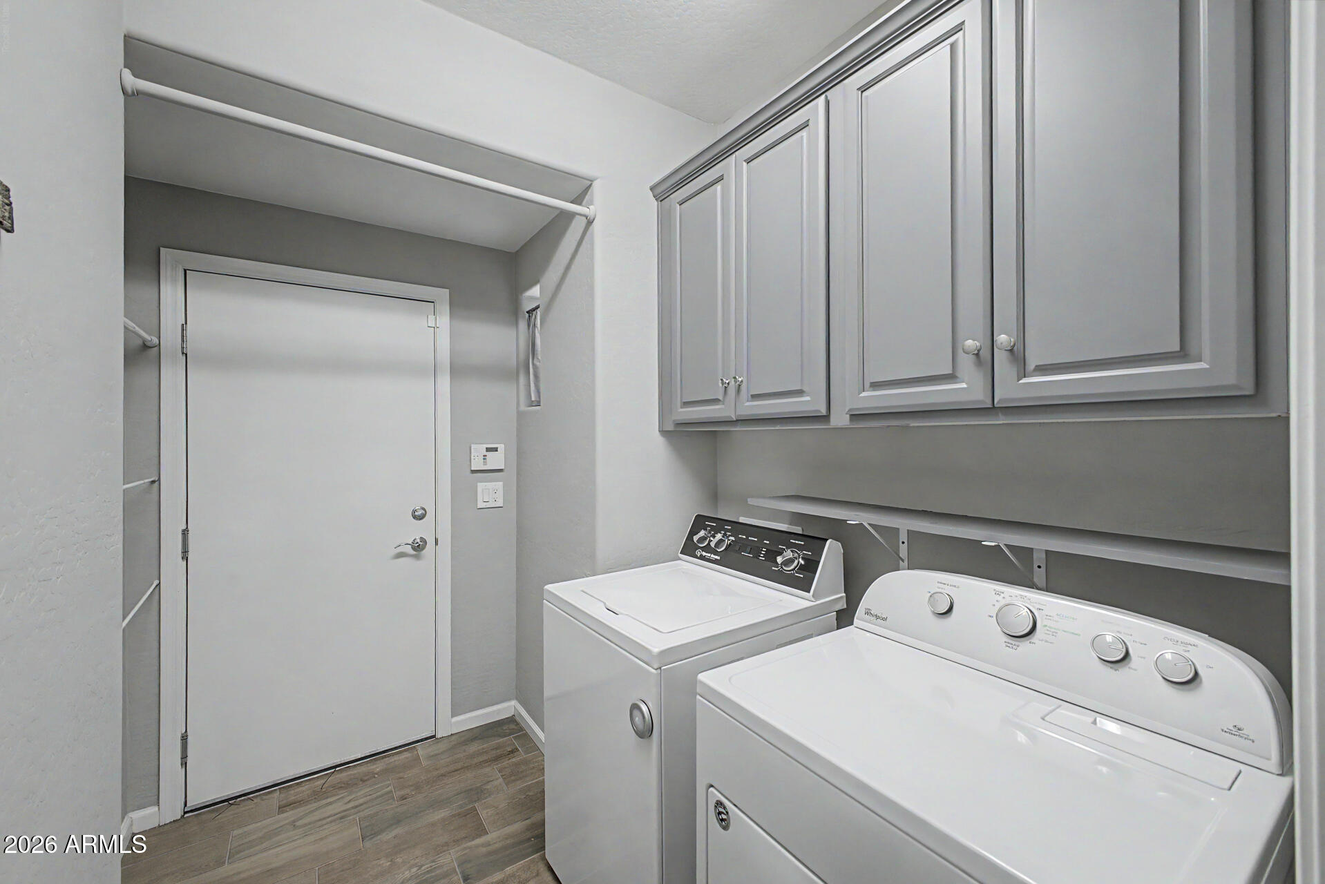 3935 East Rough Rider Road, Unit 1339 Phoenix, AZ 85050 - Photo 16 of 36 a view of washer and dryer with kitchen in the background