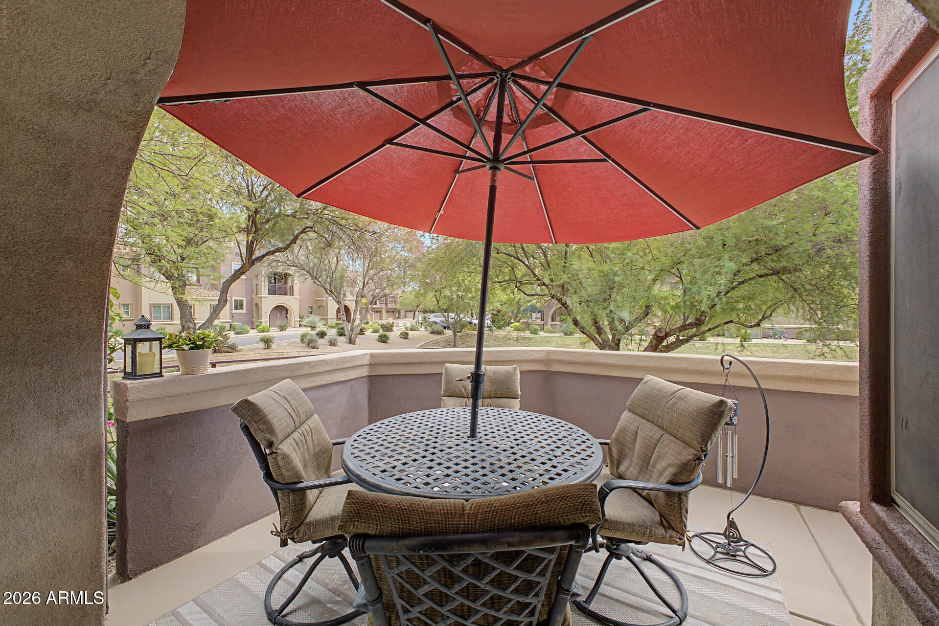 3935 East Rough Rider Road, Unit 1339 Phoenix, AZ 85050 - Photo 30 of 36 a view of a patio with table and chairs under an umbrella