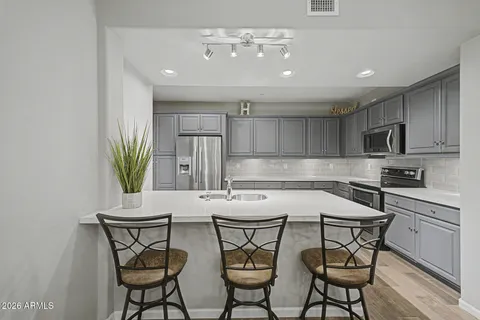 a living room with furniture and a flat screen tv with kitchen view