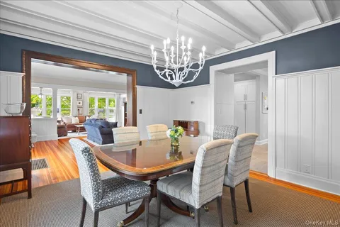 a view of a dining room with furniture a chandelier and a window