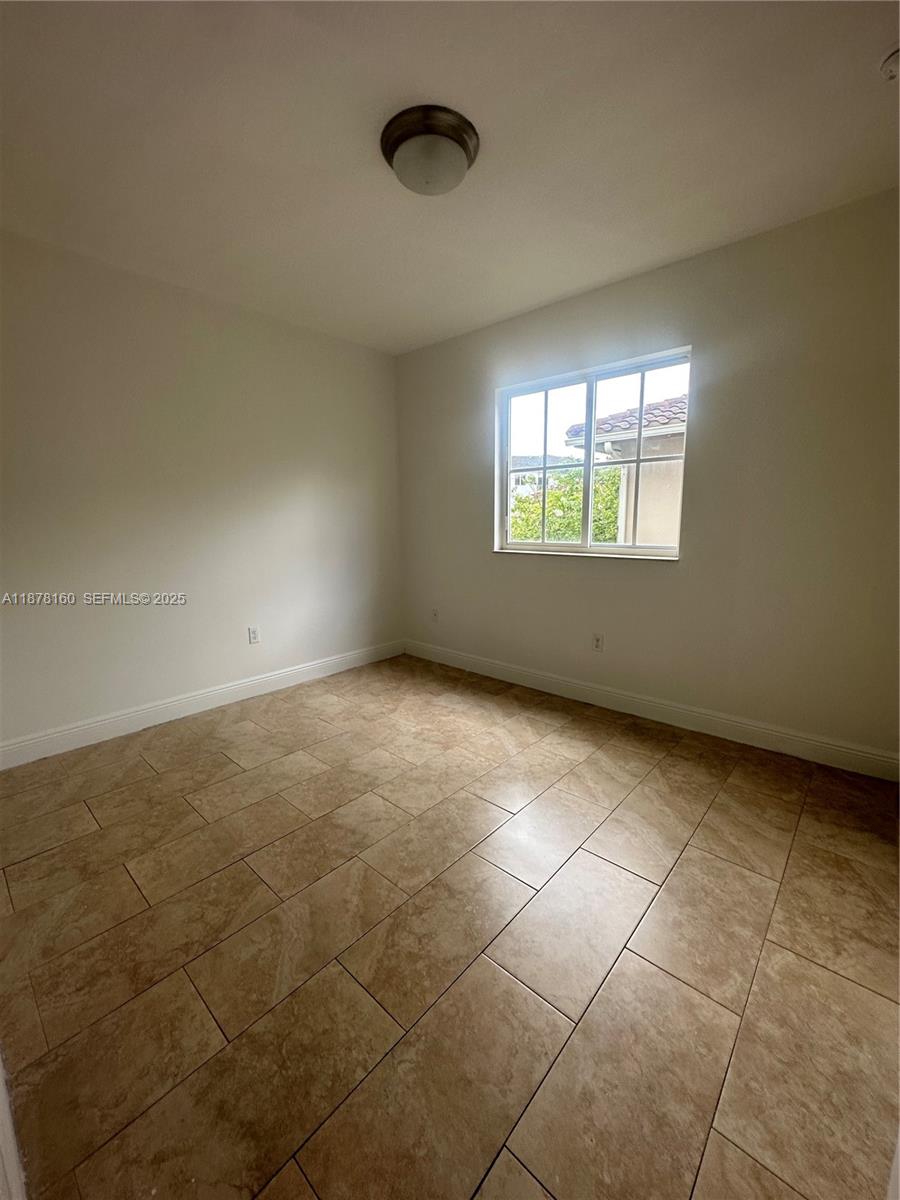 211 West 79th Place, Unit 302 Hialeah, FL 33014 - Photo 15 of 16 an empty room with a empty space and windows