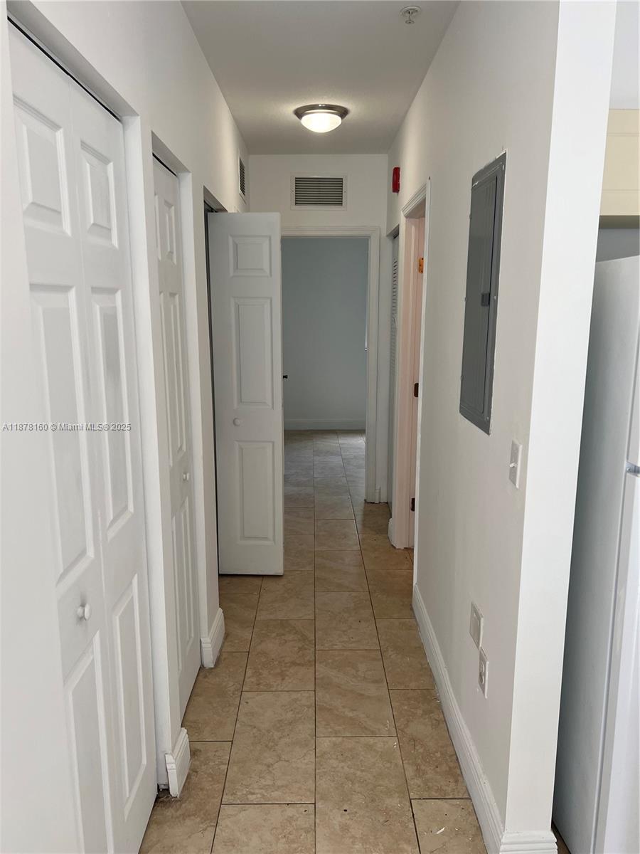 211 West 79th Place, Unit 302 Hialeah, FL 33014 - Photo 4 of 16 a view of a hallway with wooden shelves