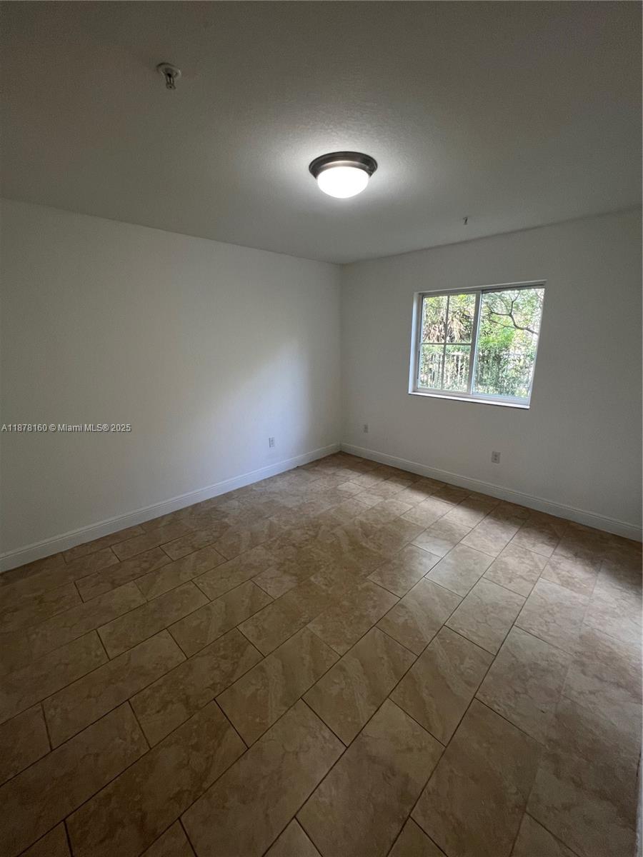 211 West 79th Place, Unit 302 Hialeah, FL 33014 - Photo 9 of 16 an empty room with windows