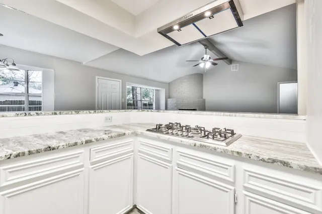 a kitchen with a stove cabinets and window