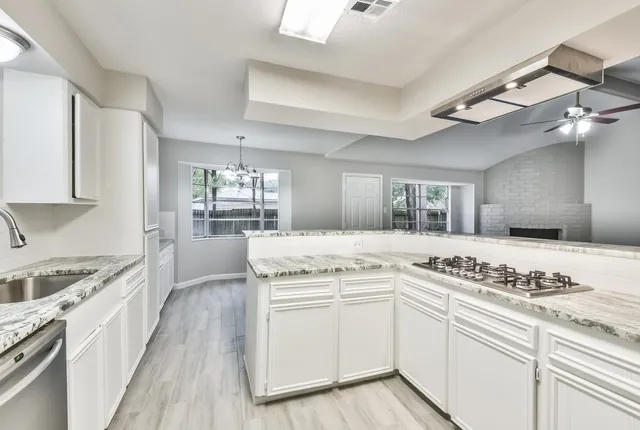 a kitchen with granite countertop white cabinets and white appliances